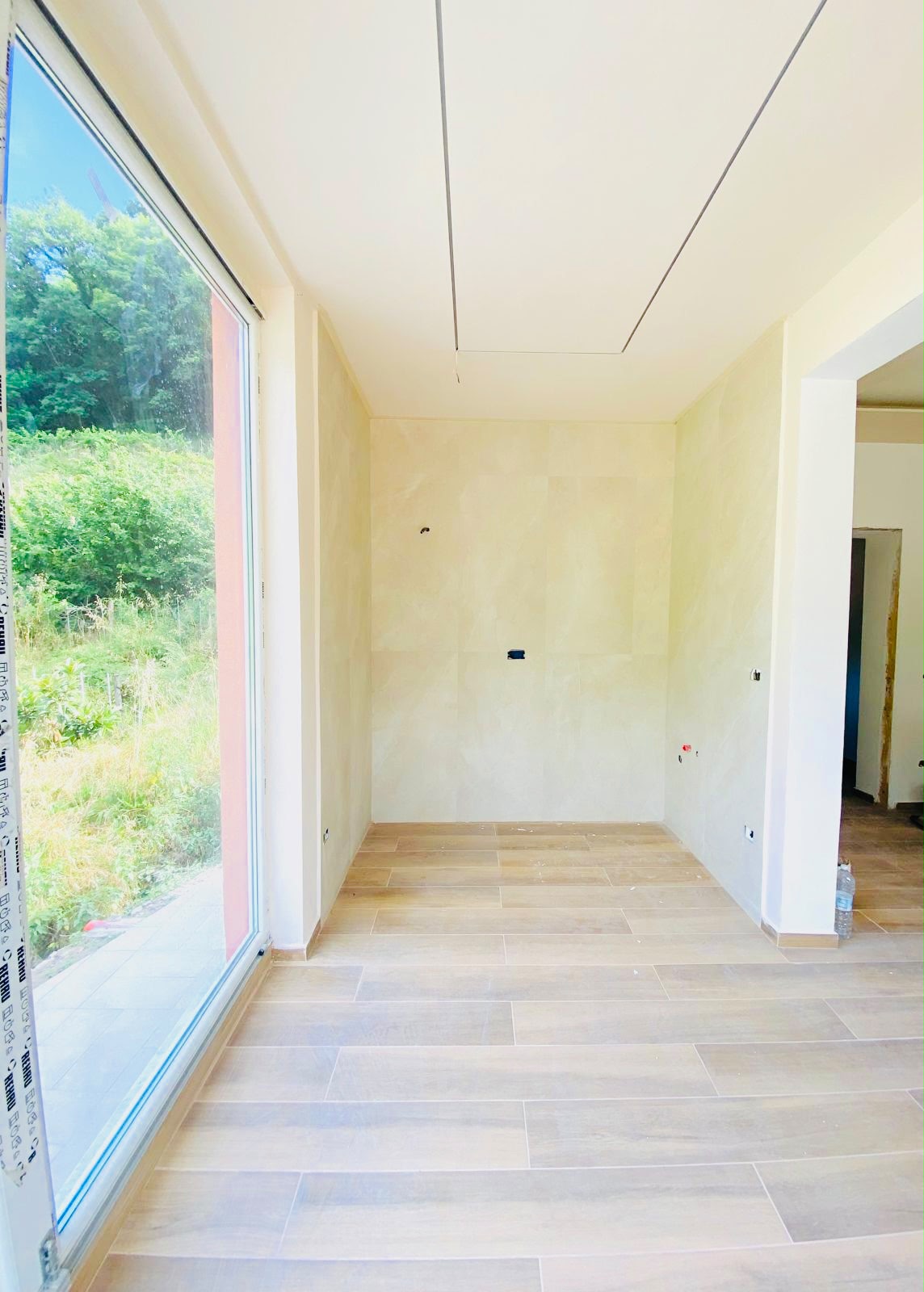 Una parete di vetro sul verde – Nuova costruzione con giardino privato
